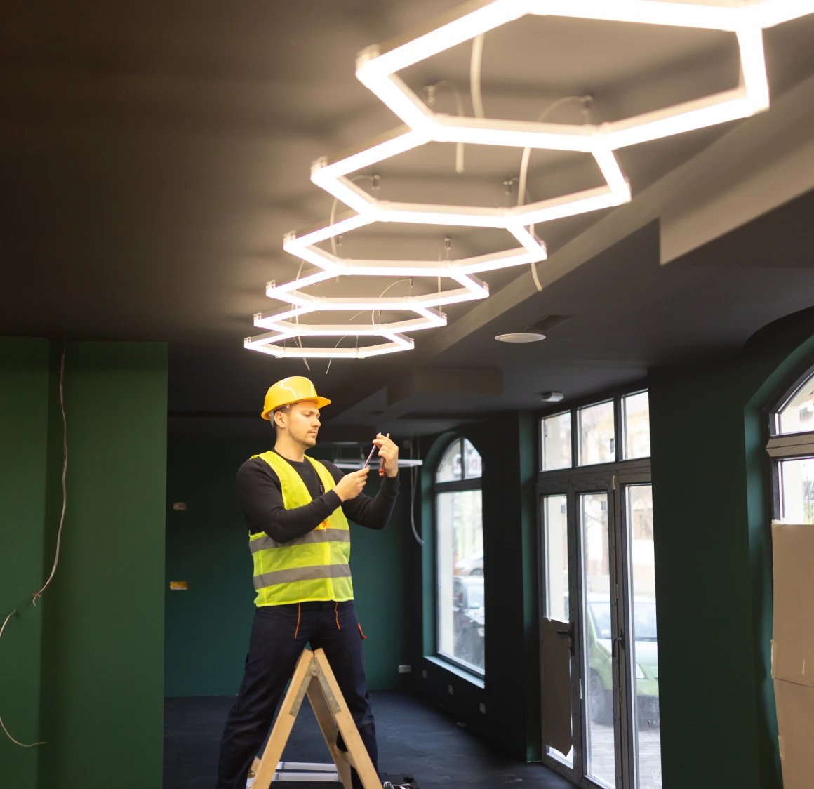 Man adjusting modern ceiling fixtures